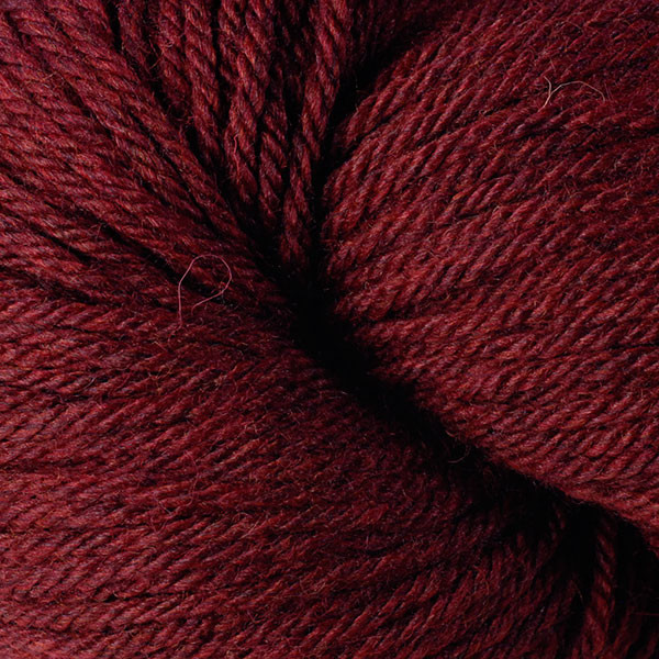 A close up of a skein of Berroco Vintage worsted weight yarn in dark maroon red color