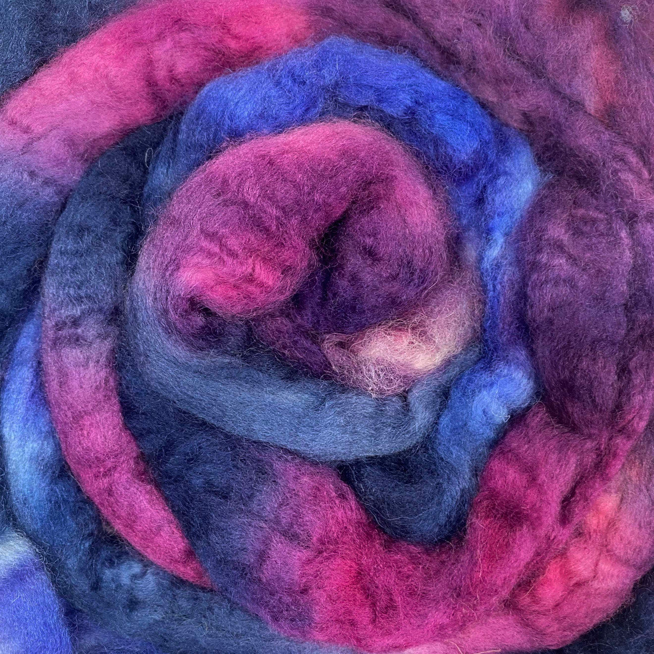 A close up of Frabjous Fibers BFL Spinning Fiber in blue, pink, and purple colors