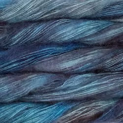 An image of multiple skeins of Malabrigo Mohair yarn in gray blue, sky blue, and navy shades.