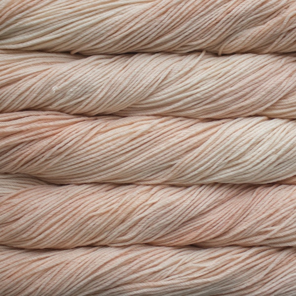 Close-up of peach colored yarn skeins stacked on top of each other