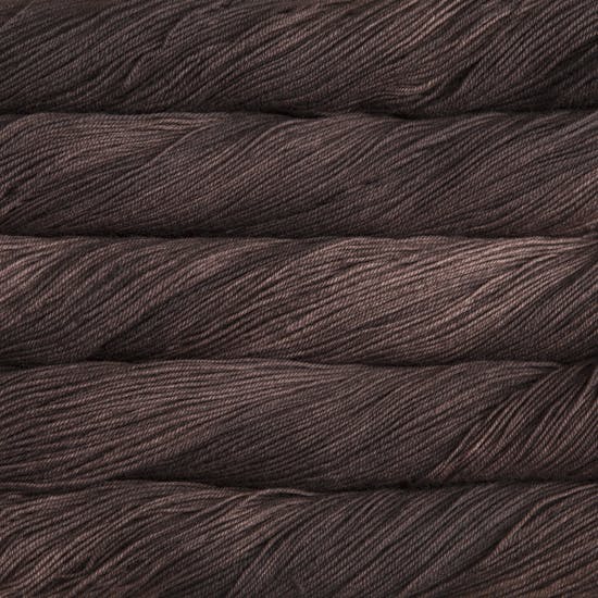 A close-up image of skeins of Malabrigo Sock yarn in chocolate brown.