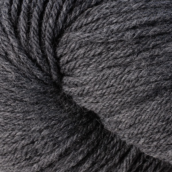 A close up of a skein of Berroco Vintage worsted weight yarn in dark grey / light black color