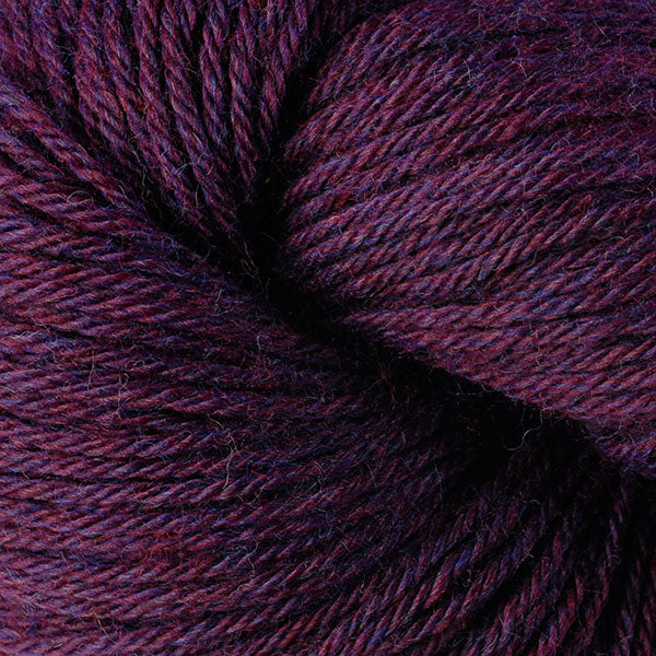 A close up of a skein of Berroco Vintage worsted weight yarn in deep reddish purple color