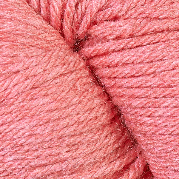 A close up of a skein of Berroco Vintage worsted weight yarn in heathered pale salmon orange color