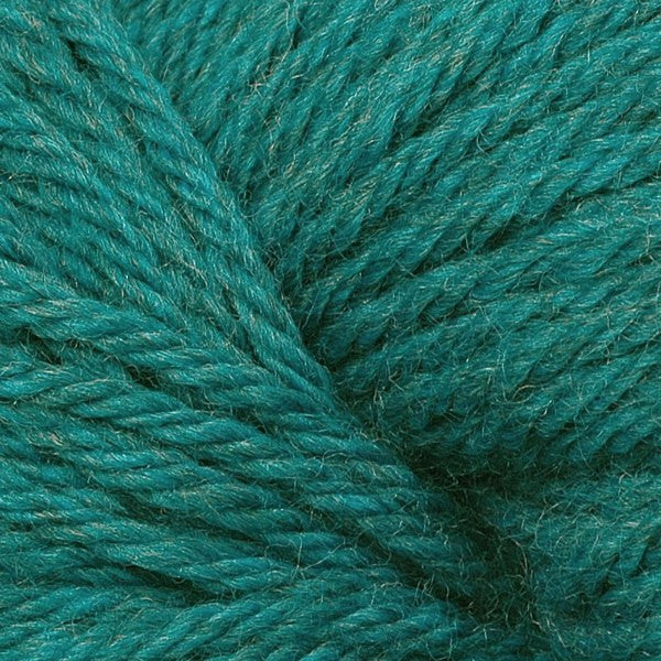 A close up of a skein of Berroco Vintage worsted weight yarn in deep teal green color