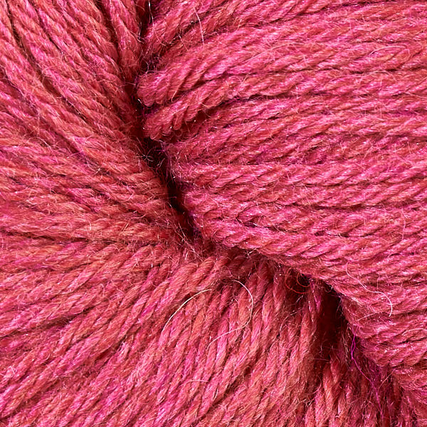 A close up of a skein of Berroco Vintage worsted weight yarn in heathered deep pink color