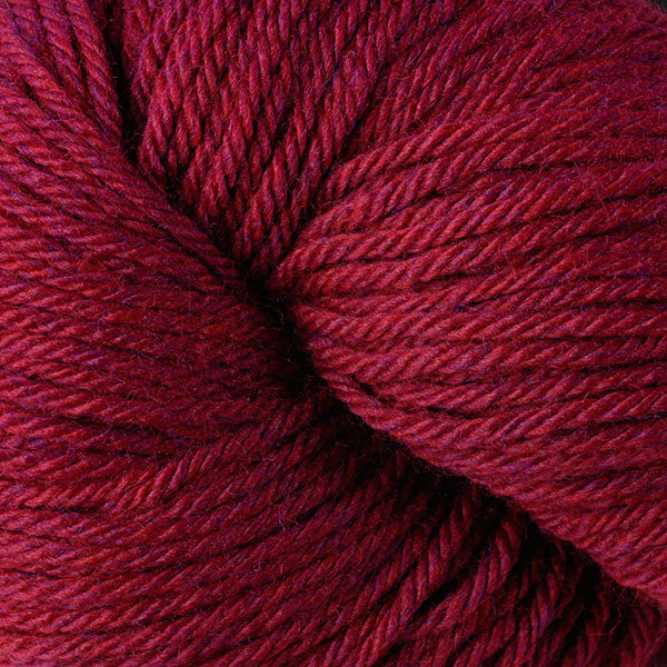 A close up of a skein of Berroco Vintage worsted weight yarn in maroom red color