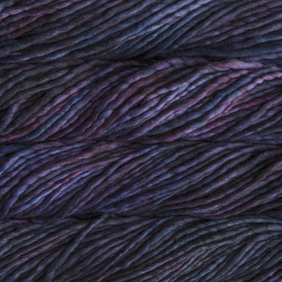 A close-up image of skeins of Malabrigo Rasta yarn in shades of dark purple and navy, displaying the texture and color variation.