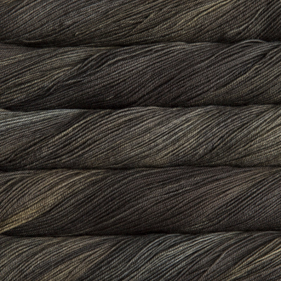 A close-up image of skeins of Malabrigo Sock yarn in dark green and charcoal shades.