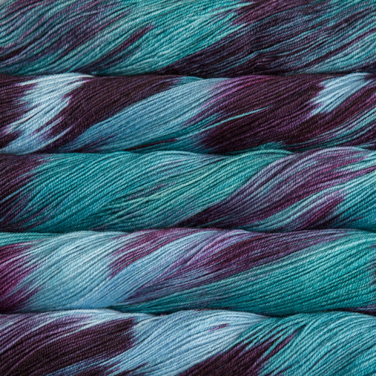 A close-up image of skeins of Malabrigo Sock yarn in shades of sky blue and purple.