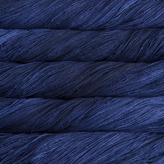 A close-up image of skeins of Malabrigo Sock yarn in indigo blue.