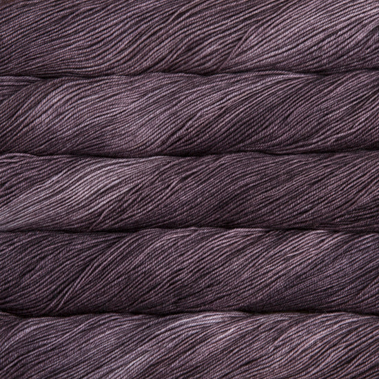 A close-up image of skeins of Malabrigo Sock yarn in deep purple.