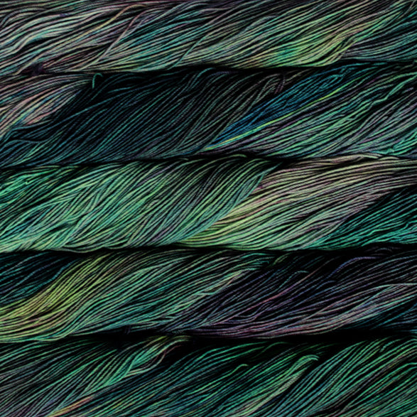 A close-up image of skeins of Malabrigo Sock yarn in deep green and purple shades.