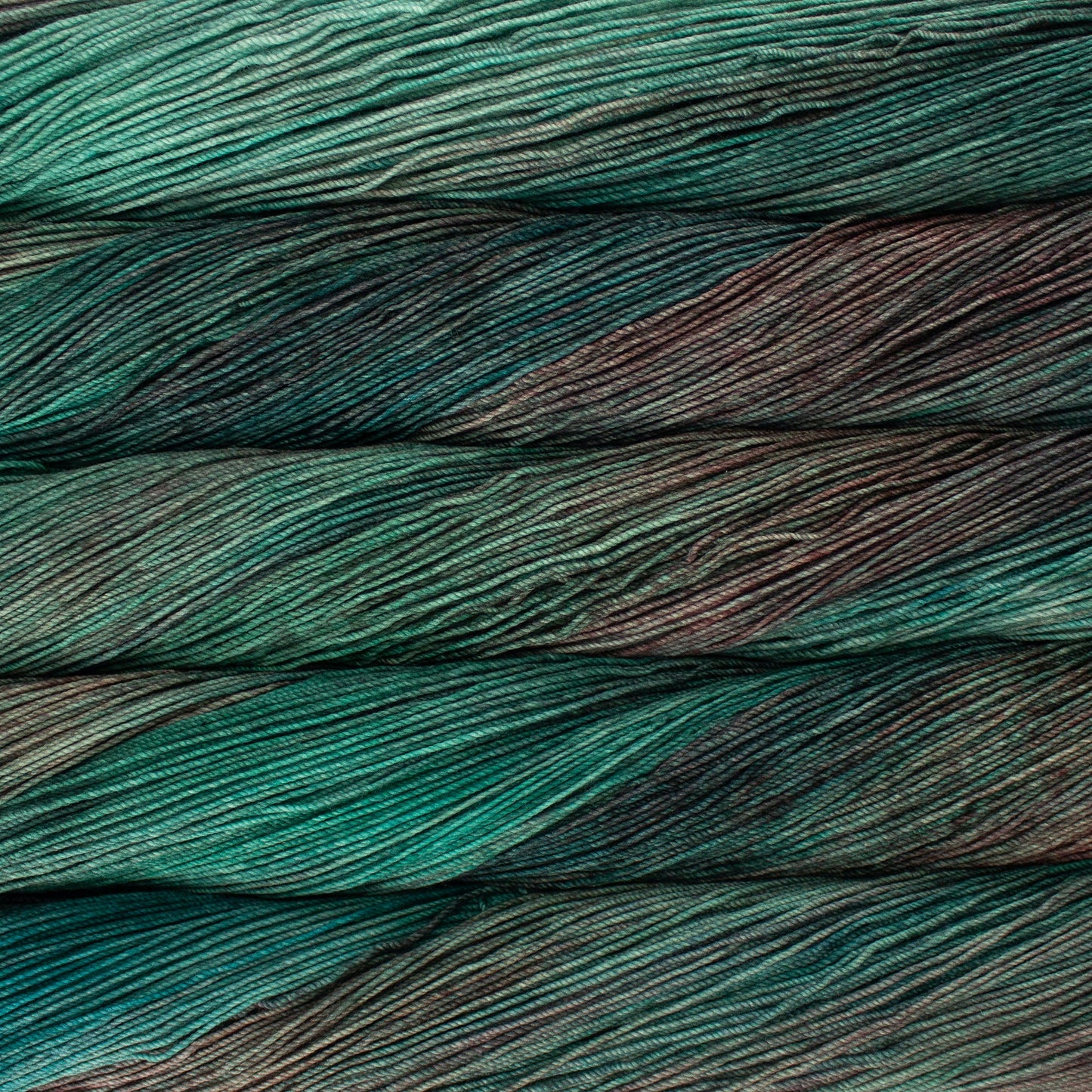 A close-up image of skeins of Malabrigo Sock yarn in turquoise, teal, and purple gray.