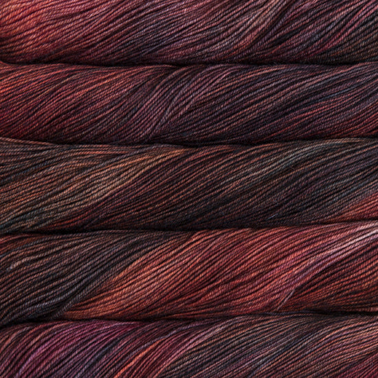A close-up image of skeins of Malabrigo Sock yarn in shades of brown, purple, and red.