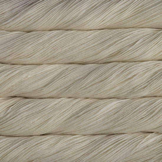 A close-up image of skeins of Malabrigo Sock yarn in a soft, off-white shade.
