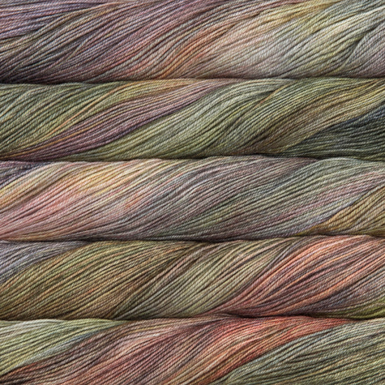 A close-up image of skeins of Malabrigo Sock yarn in pale shades of green, purple, and red.