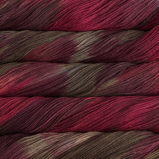 A close-up image of skeins of Malabrigo Sock yarn in chocolate brown and red.