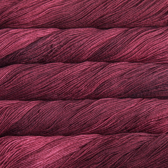 A close-up image of skeins of Malabrigo Sock yarn in deep red shades.
