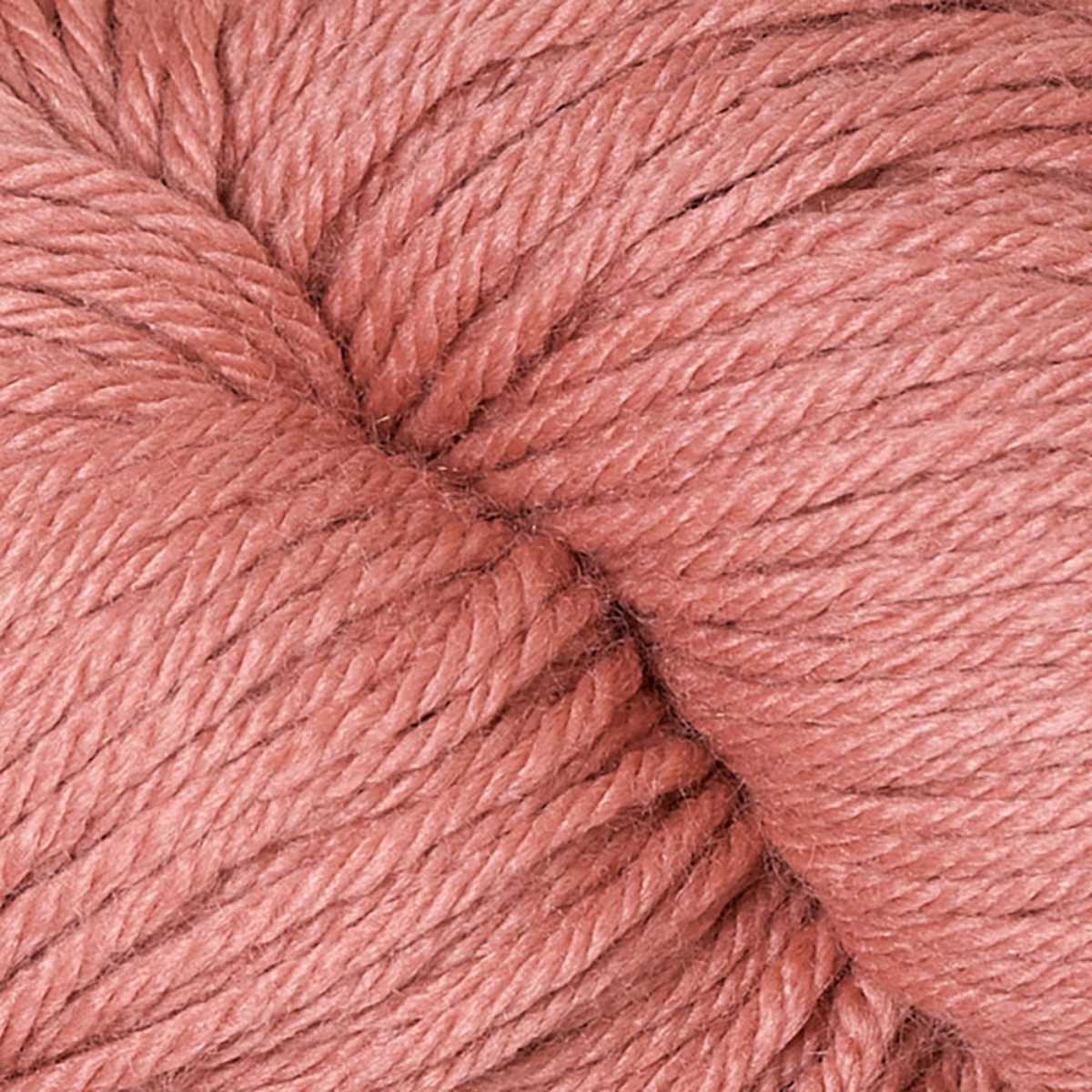 A close up of a skein of Berroco Vintage worsted weight yarn in a pale pink orange color