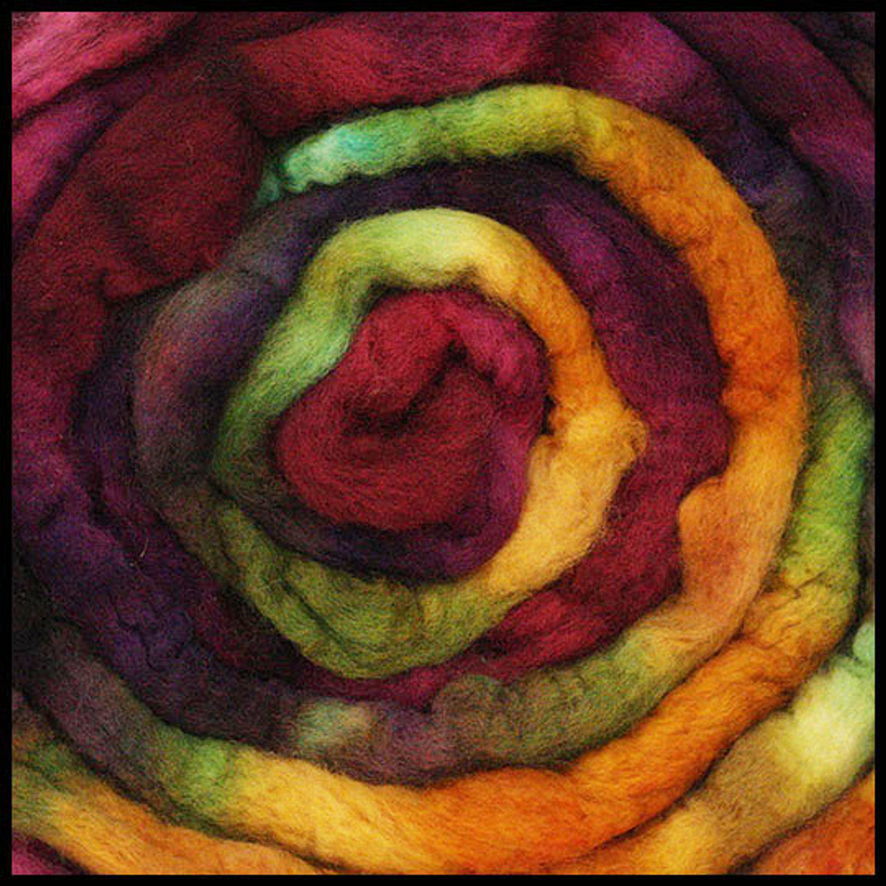 A close up of Frabjous Fibers BFL Spinning Fiber in red, green, yellow, and orange colors