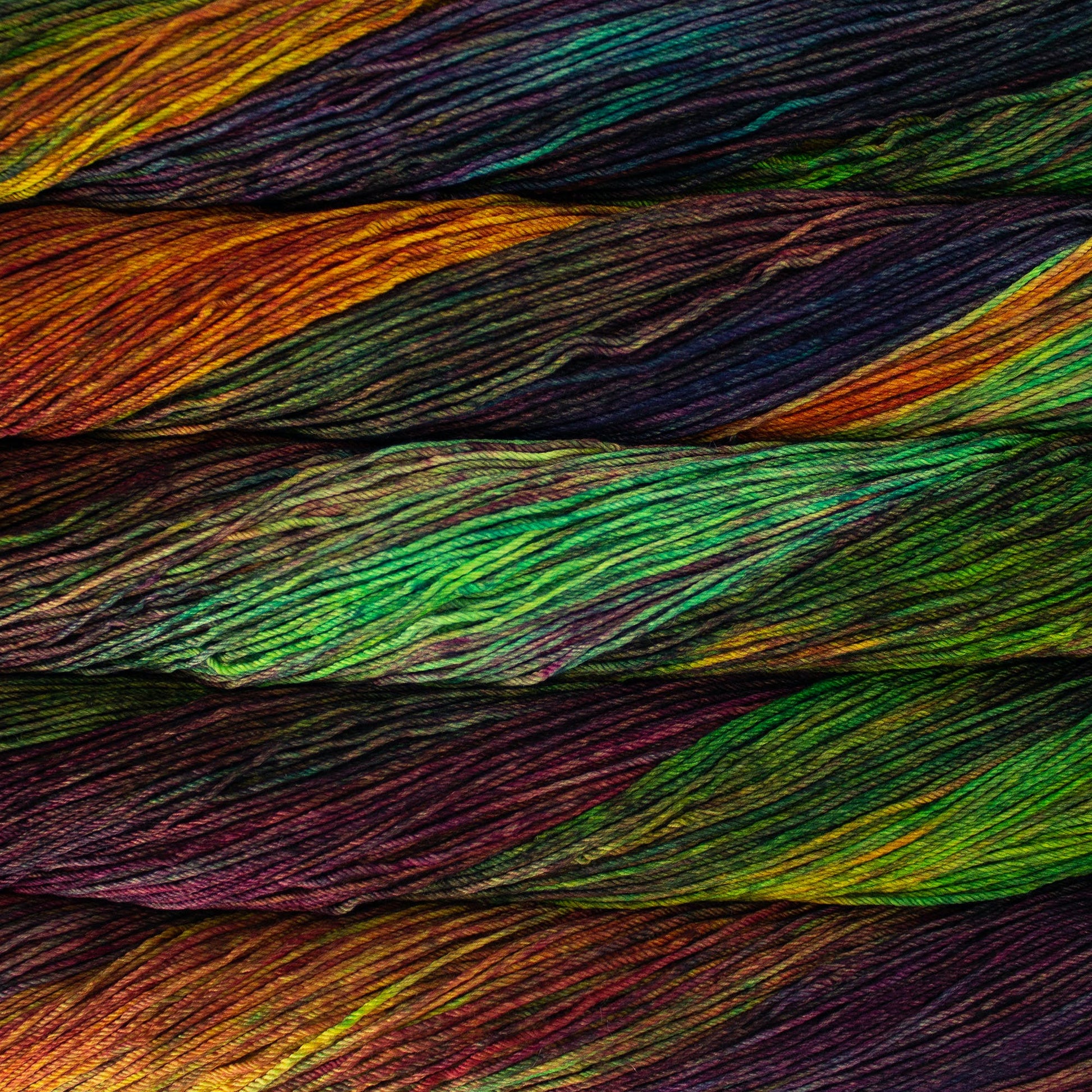 An image of skeins of Malabrigo Arroyo sport weight yarn in vibrant green, orange, red, and purple shades.