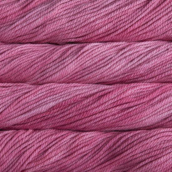 A close up image of skeins of Malabrigo Chunky bulky weight yarn in light pink and magenta shades.