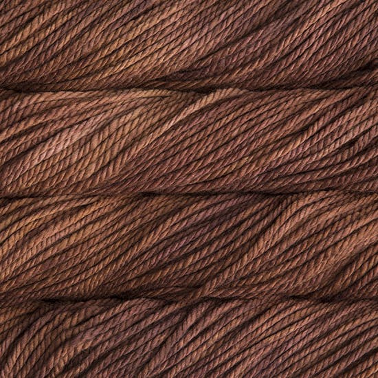 A close up image of skeins of Malabrigo Chunky bulky weight yarn in light and dark brown shades.