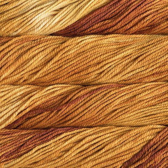 A close up image of skeins of Malabrigo Chunky bulky weight yarn in shades of yellow, orange, and copper.