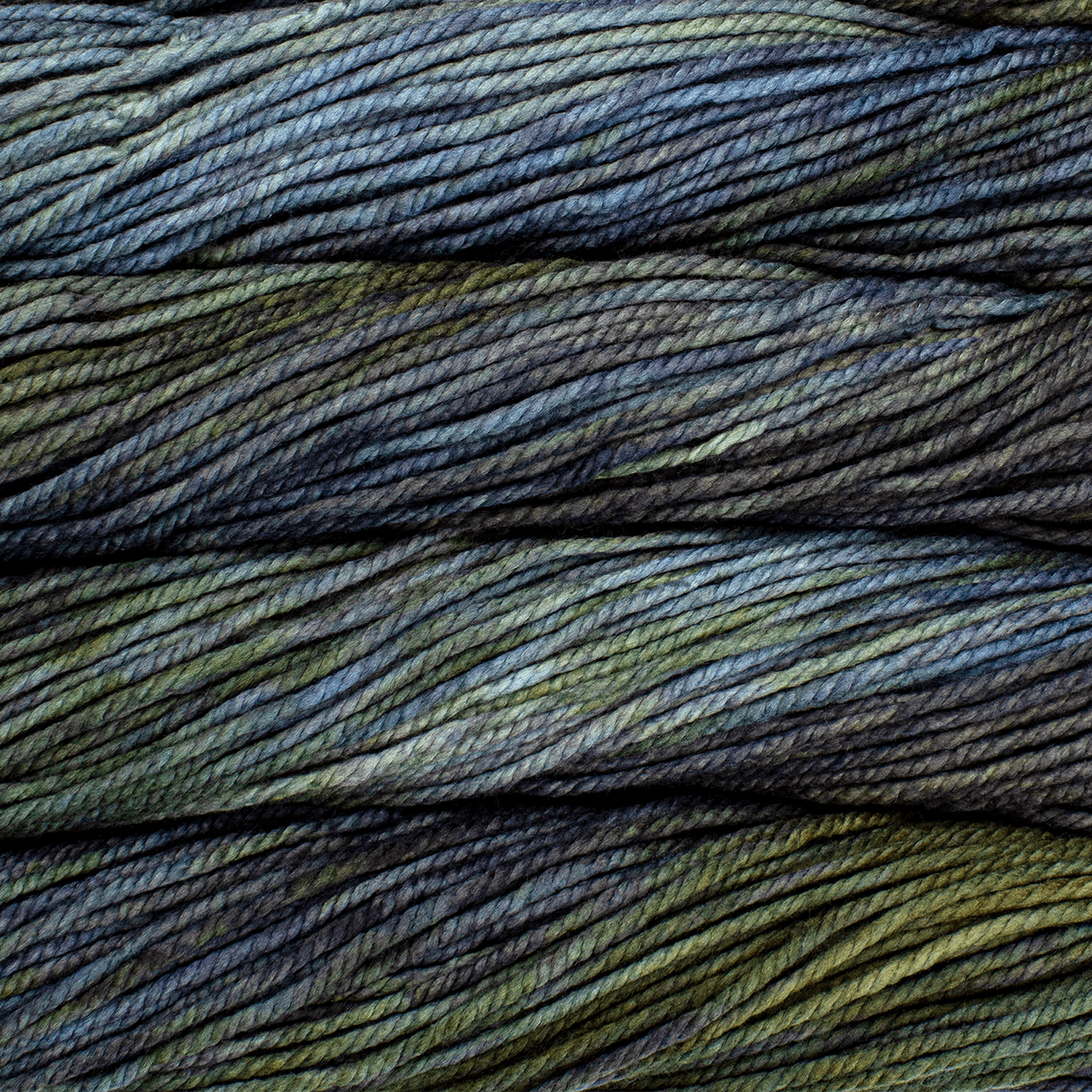 A close up image of skeins of Malabrigo Chunky bulky weight yarn in shades of blue, green, and charcoal.
