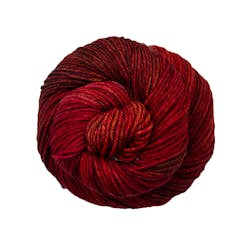 A close up of a skein of Malabrigo Rios worsted weight yarn in deep red color
