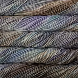 A close up of skeins of Malabrigo Rios worsted weight yarn in grey, blue, and beige colors