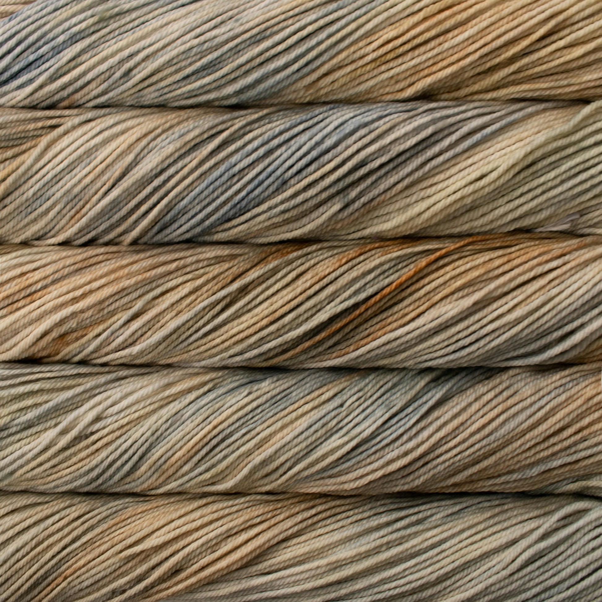 A close up of skeins of Malabrigo Rios worsted weight yarn in beige and light grey colors.