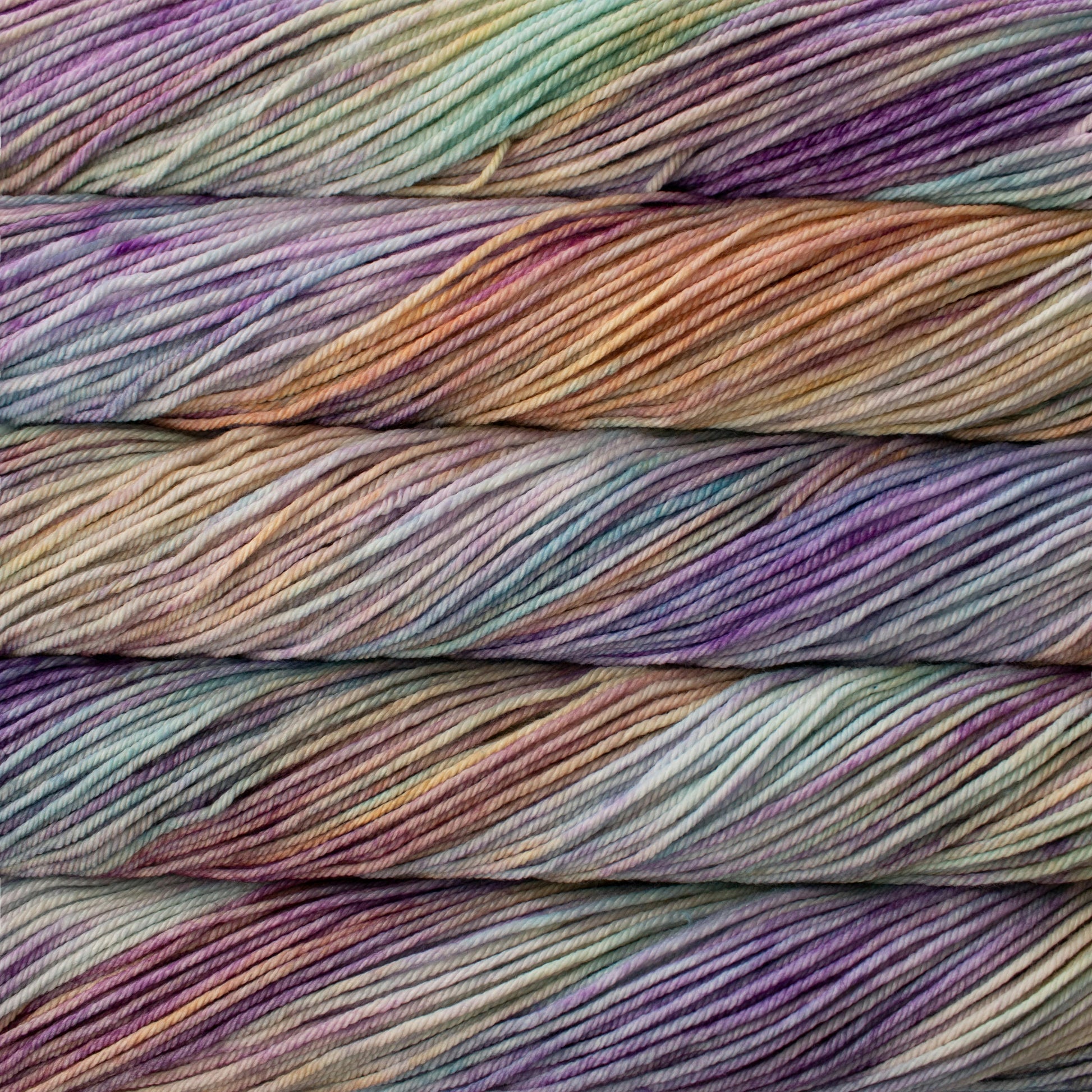 A close up of skeins of Malabrigo Rios worsted weight yarn in purple, blue, and orange colors