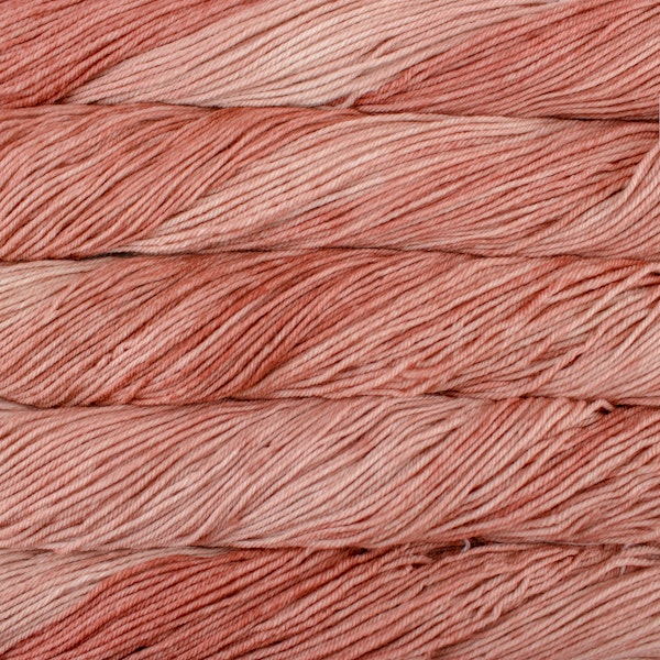 A close up of skeins of Malabrigo Rios worsted weight yarn in light muted pink color