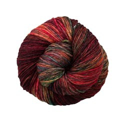 A close up of a skein of Malabrigo Rios worsted weight yarn in red, green, yellow, and orange colors