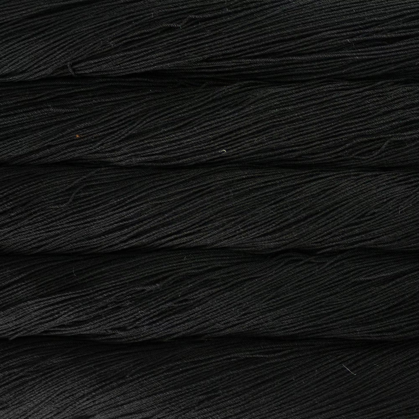 A close up of a skein of Malabrigo Ultimate Sock fingering weight yarn in black color