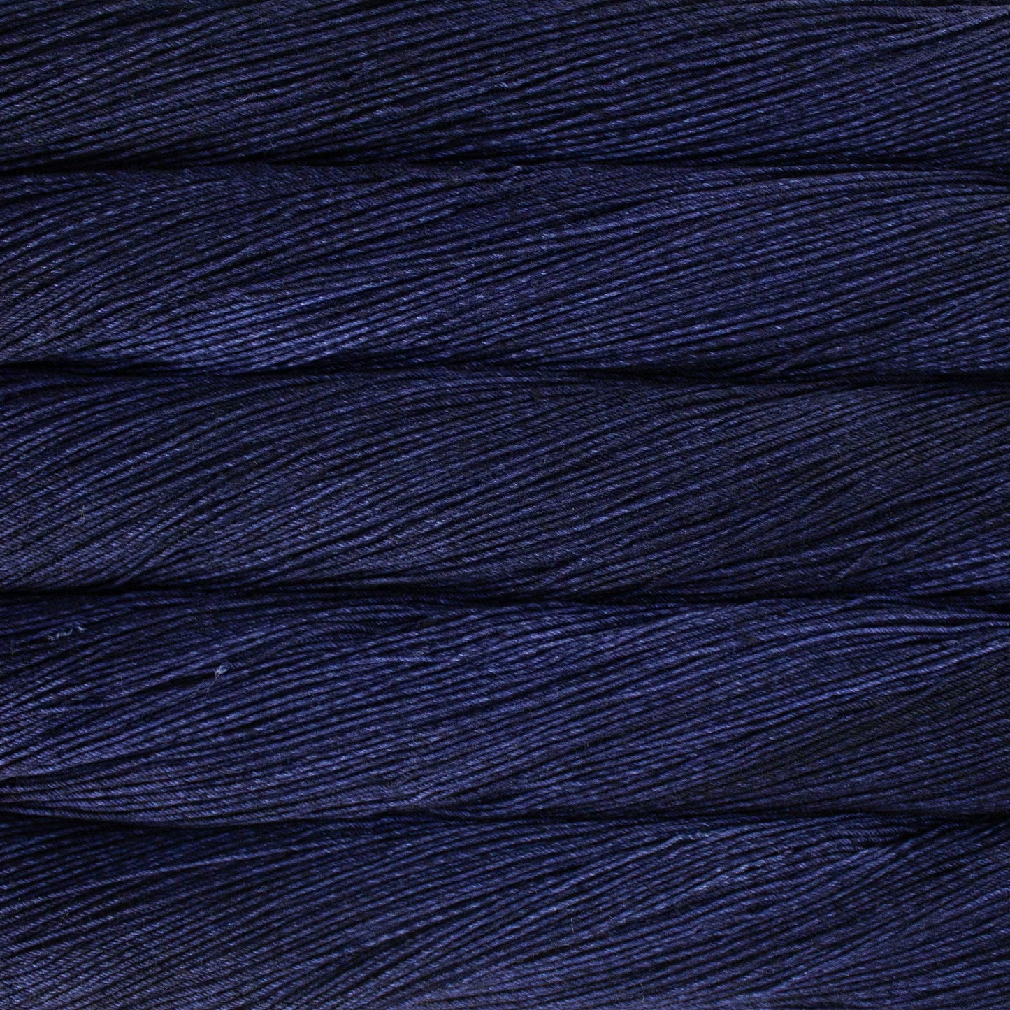 A close up of a skein of Malabrigo Ultimate Sock fingering weight yarn in dark purple color