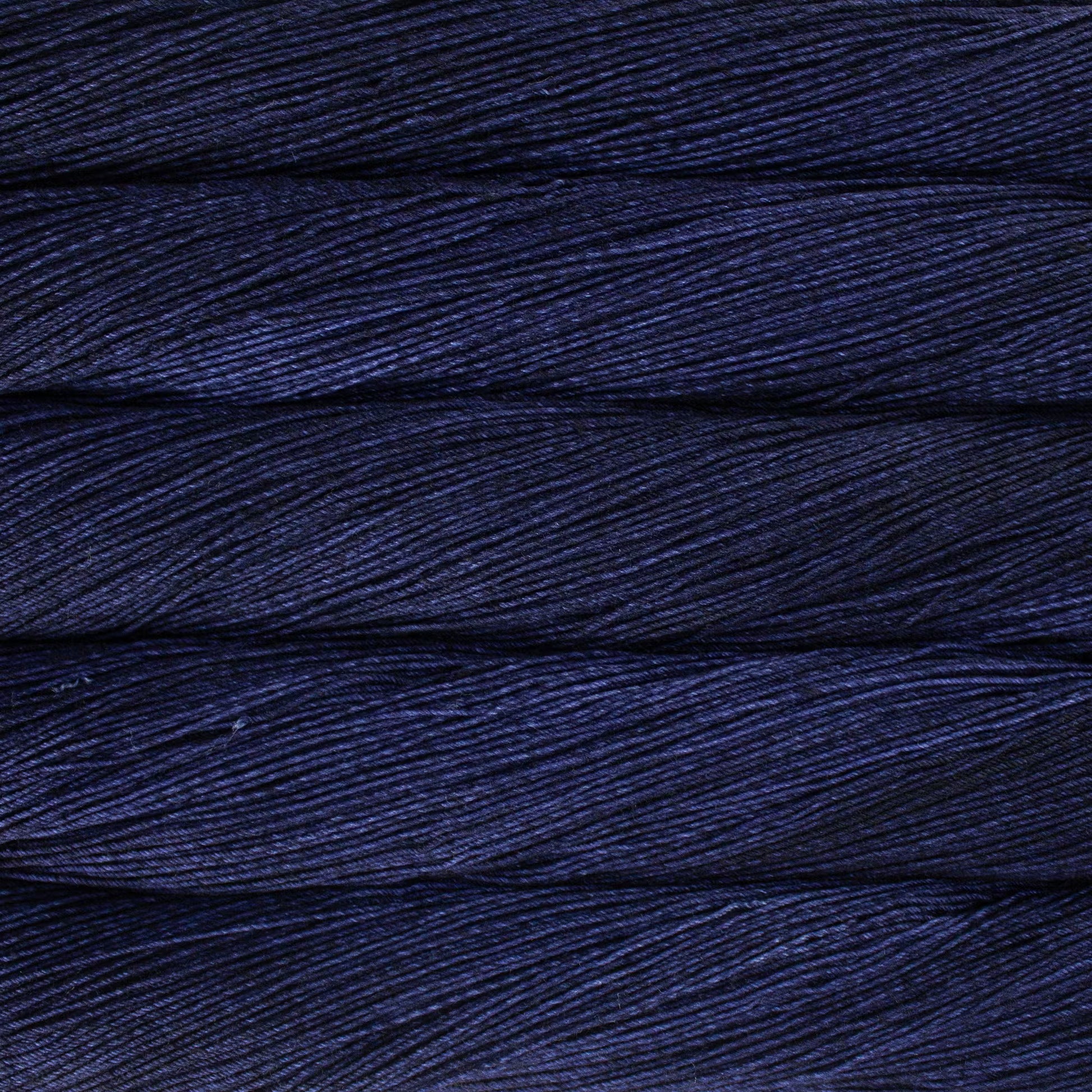 A close up of a skein of Malabrigo Ultimate Sock fingering weight yarn in dark purple color