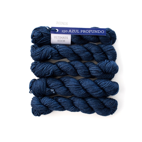 Multiple mini skeins of Malabrigo Ultimate Sock Azul Profundo, kettle dyed blue sock yarn against a white background