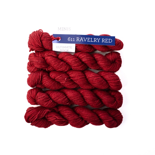 Multiple mini skeins of Malabrigo Ultimate Sock Ravelry Red, true red kettle dyed sock yarn against a white background