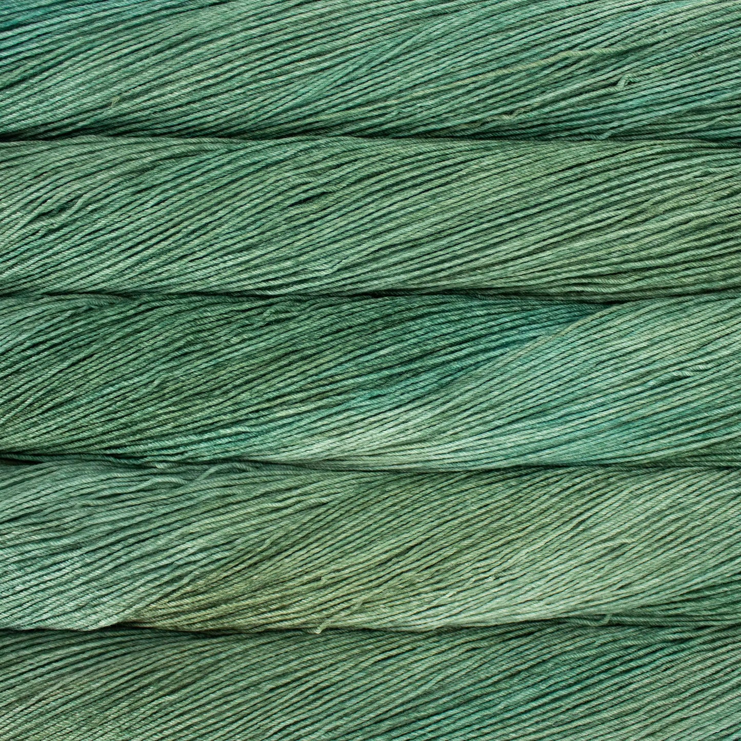 A close up of a skein of Malabrigo Ultimate Sock fingering weight yarn in muted green color