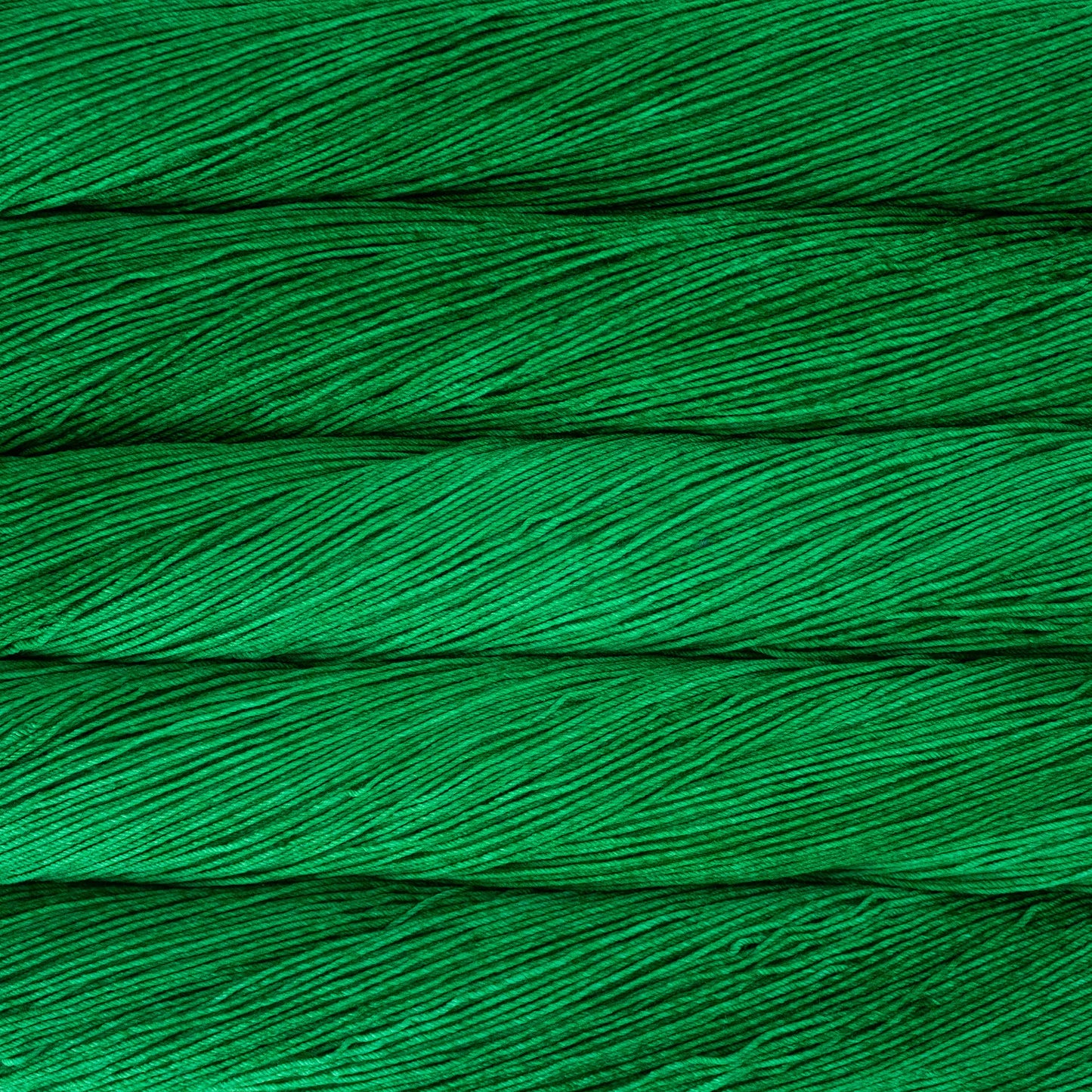 A close up of a skein of Malabrigo Ultimate Sock fingering weight yarn in vibrant green color