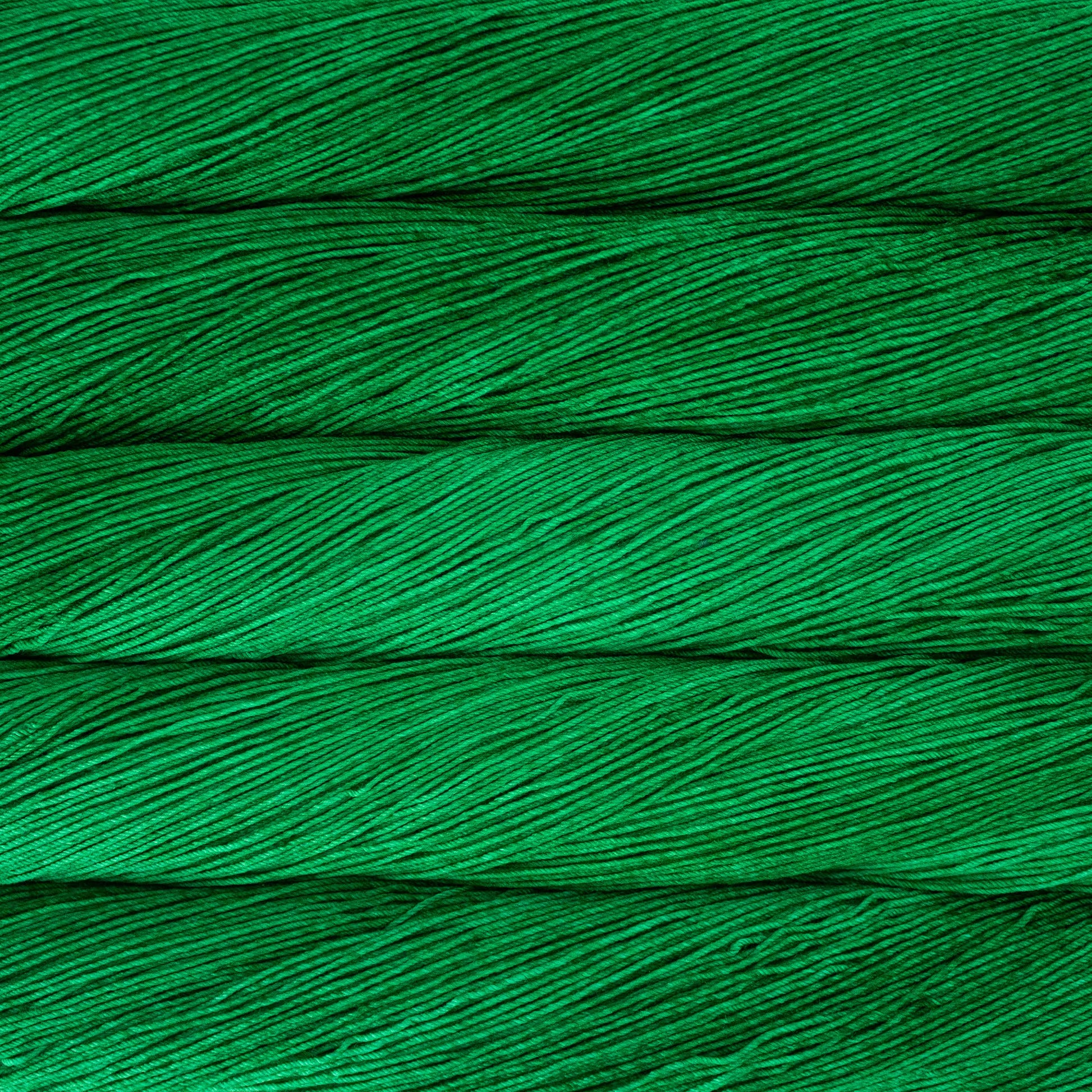 A close up of a skein of Malabrigo Ultimate Sock fingering weight yarn in vibrant green color
