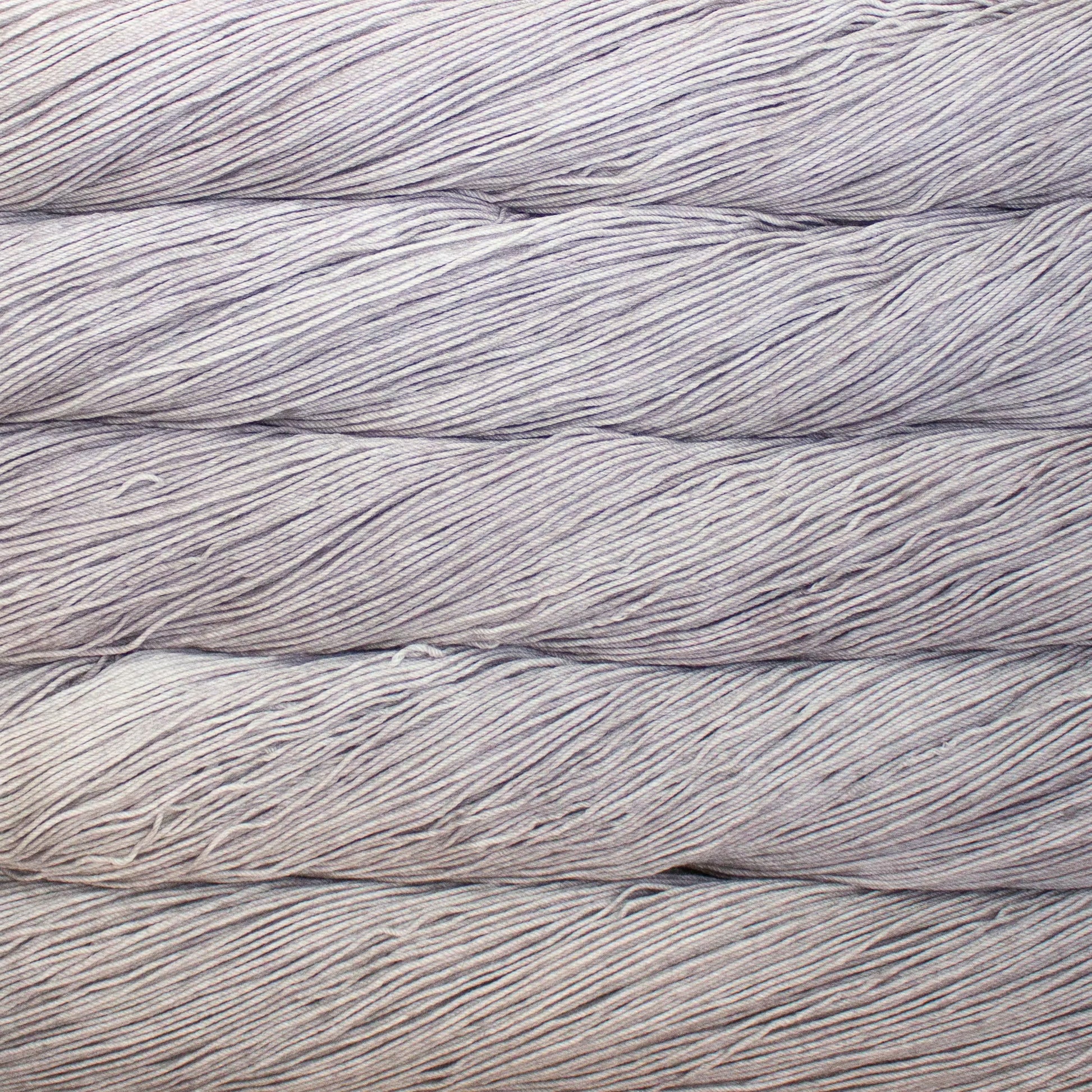 A close up of a skein of Malabrigo Ultimate Sock fingering weight yarn in light grey color