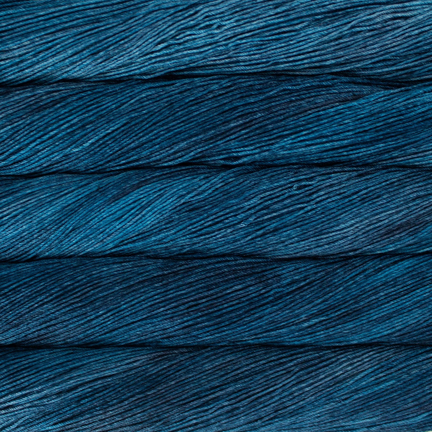 An image of skeins of Malabrigo Arroyo sport weight yarn in deep blue shades.