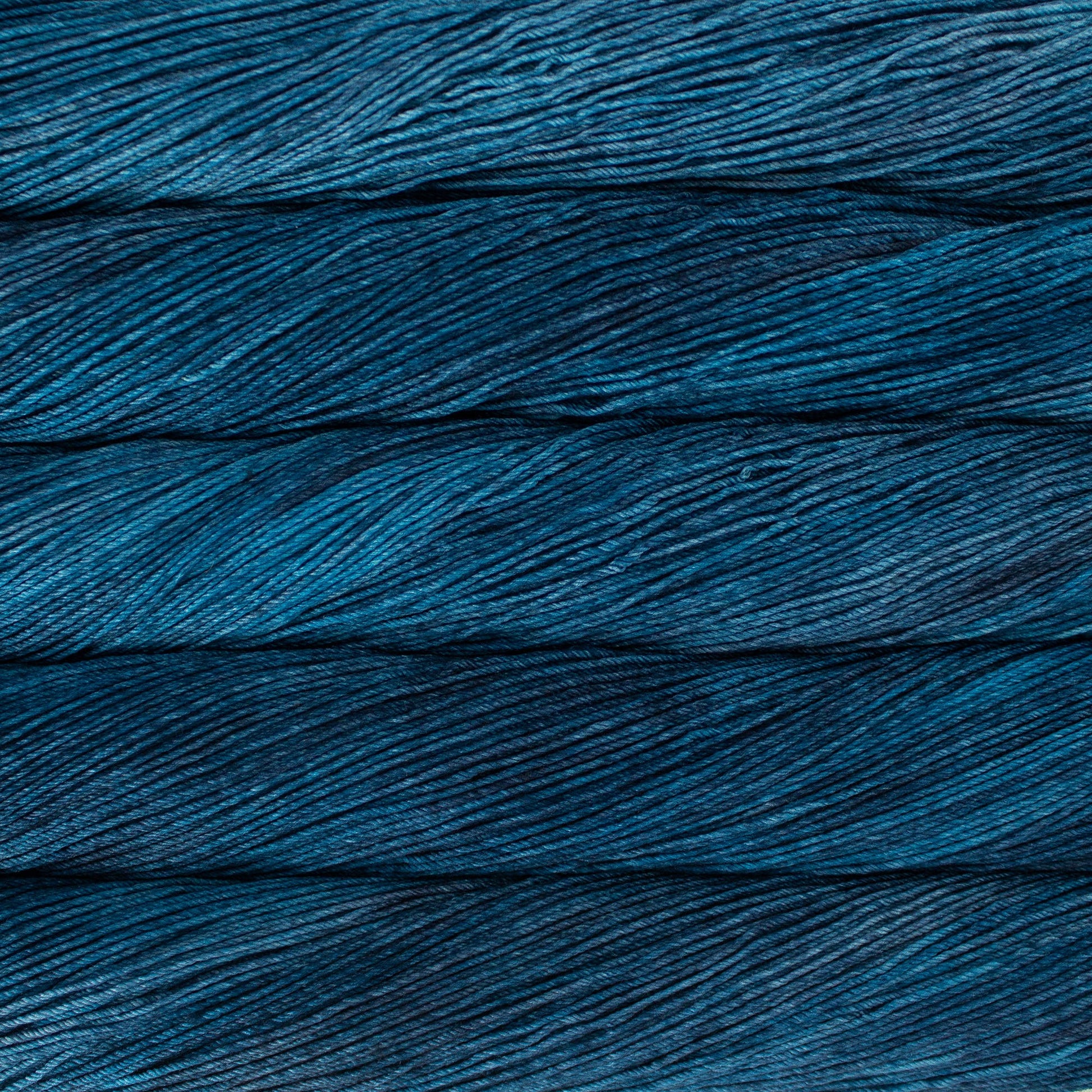 An image of skeins of Malabrigo Arroyo sport weight yarn in deep blue shades.