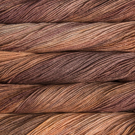 An image of skeins of Malabrigo Arroyo sport weight yarn in brown and rust orange shades.