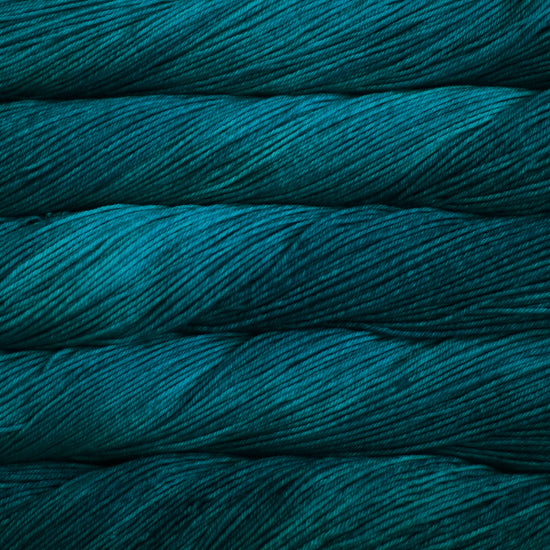 An image of skeins of Malabrigo Arroyo sport weight yarn in shades of teal.