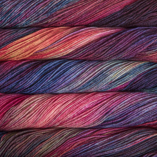 An image of skeins of Malabrigo Arroyo sport weight yarn in the color ‘Aniversario,’ in shades of blue, pink, and purple.